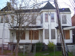 Photo of a boarded up, two-story house in East Orange NJ